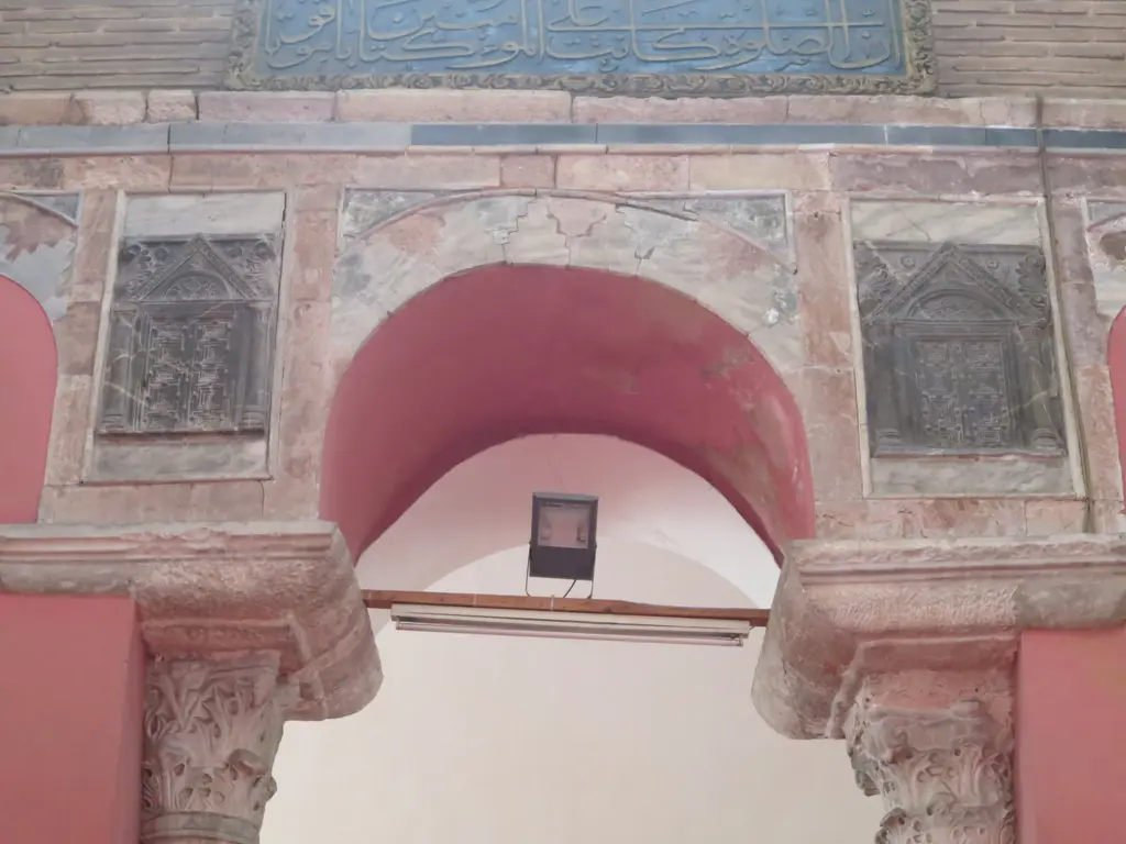 Kalenderhane Camii'nde iç narteks kapısının üstü; oymalı sütun başlıkları üstünde pembe kemer, iki yanda mermer paneller ve mavi hat kuşağı.