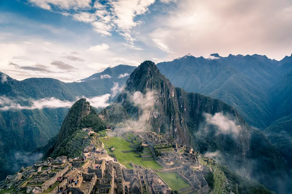 Peru'da Machu Picchu; teraslı taş yapılardan oluşan dağ sırtındaki antik şehir ve arkasında yükselen sivri Huayna Picchu tepesi.