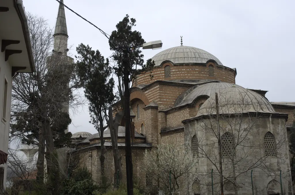 Rum Mehmed Paşa Camii; ana kubbe, yanlarda küçük tabhane kubbeleri, ağaçlar ve solda yükselen ince minare.