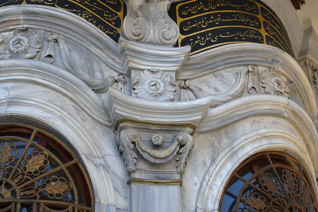 Nusretiye Camii sebilinden ayrıntı; mermer üzerinde kıvrımlı akantus yaprakları, kemerli şebekeler ve üstte yaldızlı yazı kuşağı.