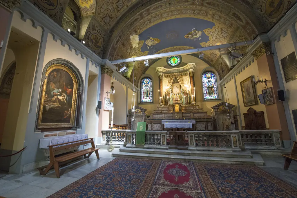 Santa Maria Draperis Kilisesi'nin içi; tavanda boyalı kubbe, altın süslemeli sunak, yan duvarlarda tablolar ve ahşap sıralar.