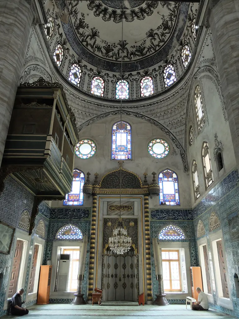 Mihrap bölümü; mermer mihrap nişi, iki yanında çinili duvarlar, solda ahşap hünkâr mahfili çıkması ve üstte kemerli pencereler.