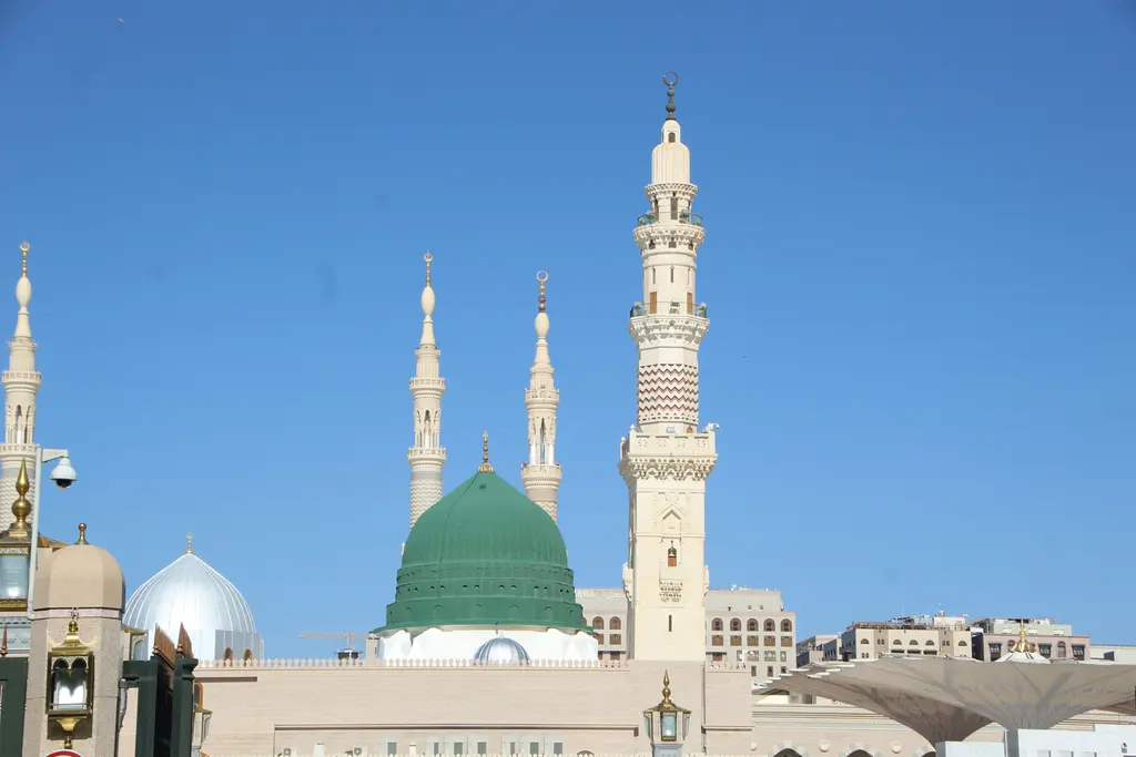 Medine'de Mescid-i Nebevi; ortada yükselen yeşil kubbe, iki yanındaki ince minareler ve önündeki beyaz kubbeli çatı bölümü.