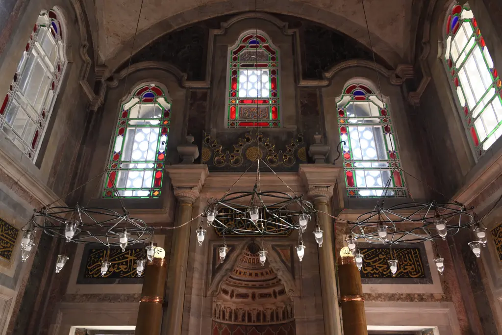 Laleli Camii'nde mihrap duvarı; renkli mermer levhalarla kaplı yüzey, üstünde renkli camlı pencereler ve iki yanda mermer sütunlar.