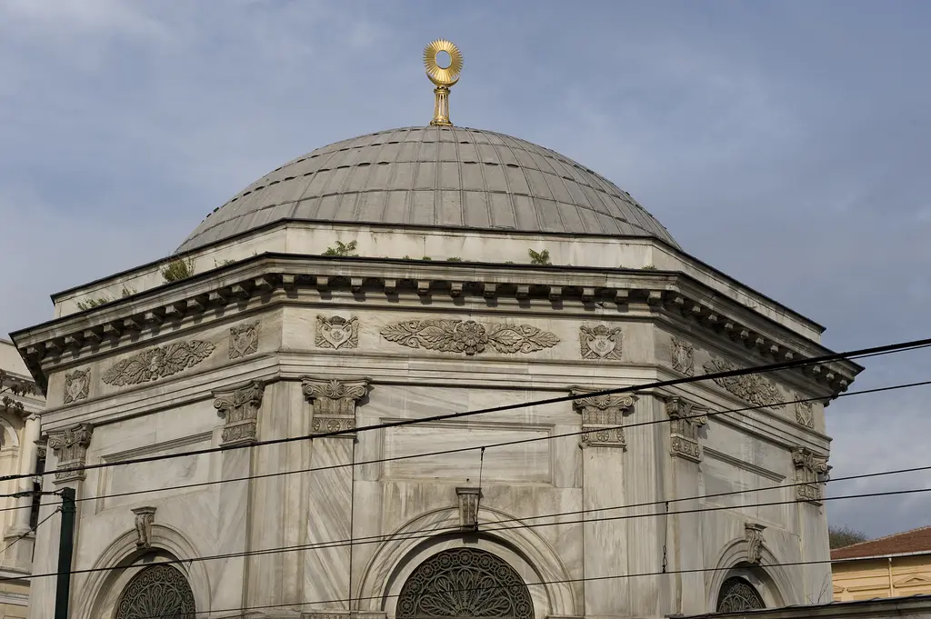 II. Mahmud Türbesi'nin kubbesi; sekizgen kasnak, kurşun kaplama, altın alem, altta pilastırlı mermer cephe, kemerli pencereler ve önden geçen teller.