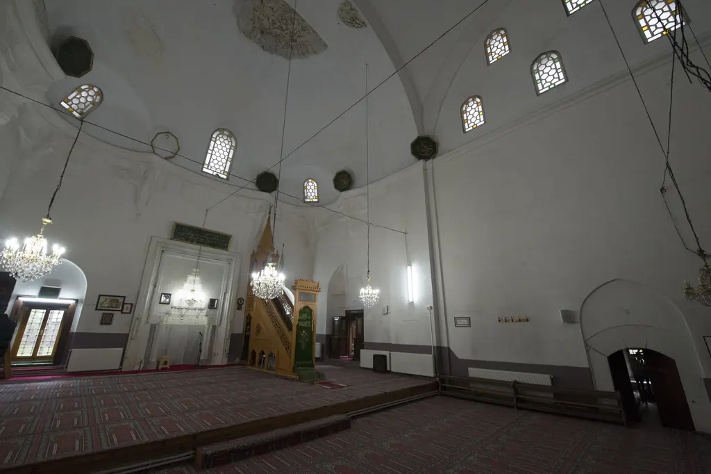 Rum Mehmed Paşa Camii'nin harimi; geniş açıyla beyaz duvarlar, kubbe pencereleri, mihrap, minber ve kırmızı halı.