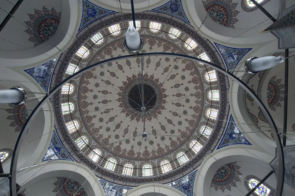 Azapkapı Sokullu Mehmed Paşa Camii'nin kubbesi; kırmızı ve lacivert kalem işleri, kasnakta pencereler, köşelerde trompler ve avize çemberi.