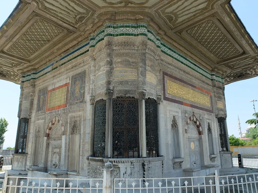 Çeşmenin kuzey köşesi; yuvarlak sebil gövdesi, üstünde kitabe kuşağı, yanlarda kemerli cephe uçları ve kurşun kubbecik.