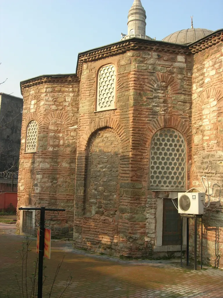 Atik Mustafa Paşa Camii'nin doğu ucu; yan yana üç tuğla apsis, kemerli nişler içinde şebekeli pencereler, arkada kurşun kaplı kubbe ile minarenin şerefesi.