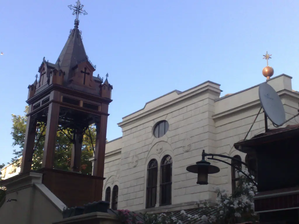 Kadıköy'de Surp Takavor Kilisesi; sokaktan bakışla kilise cephesi, sivri külahlı çan kulesi ve avlu duvarı.