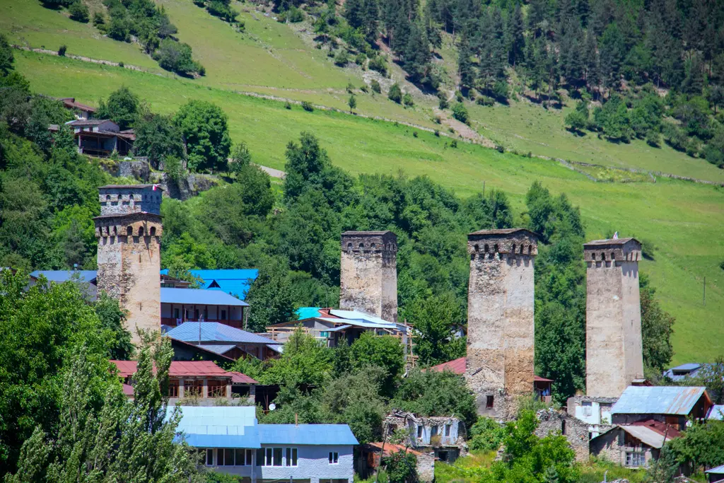 Svaneti'de Mestia kasabası; yeşil vadi içinde sıralanan Svan taş kuleleri ve arkada karlı Kafkas zirveleri.