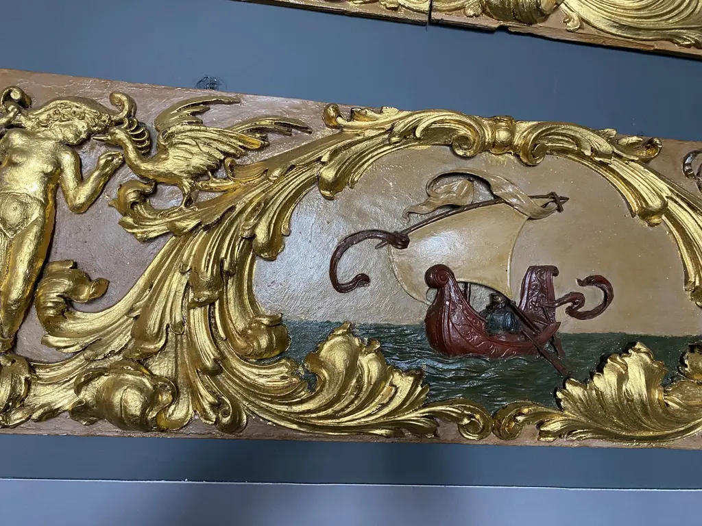 İstanbul Deniz Müzesi'nde yaldızlı kabartma pano; altın kıvrık dallar arasında dalgalar üzerinde bir yelkenli tasviri.