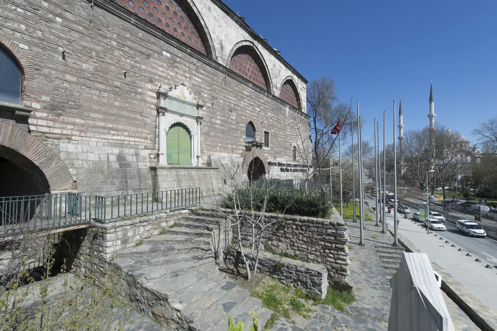 Tophane-i Âmire'nin Boğaz'a bakan tarafı; yüksek taş duvar, mermer çerçeveli yeşil kapı ve aşağı inen taş merdivenler.
