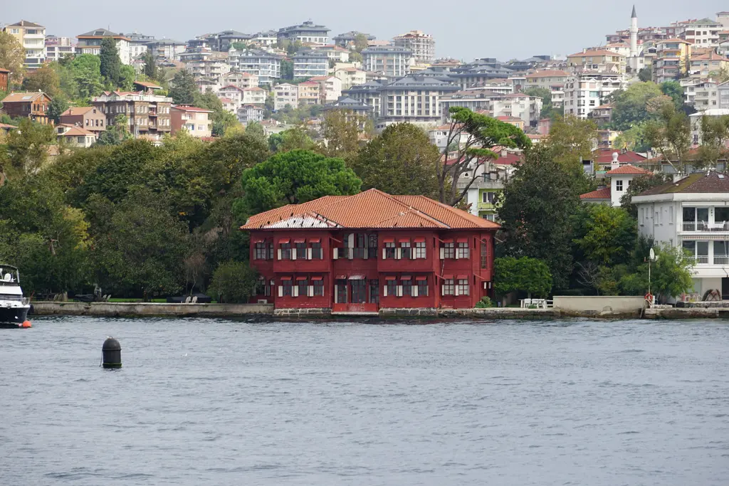 Çengelköy'de Boğaz kıyısındaki Sadullah Paşa Yalısı; kiremit kırmızısı ahşap cephe, kırma çatı ve arkada ağaçlar.
