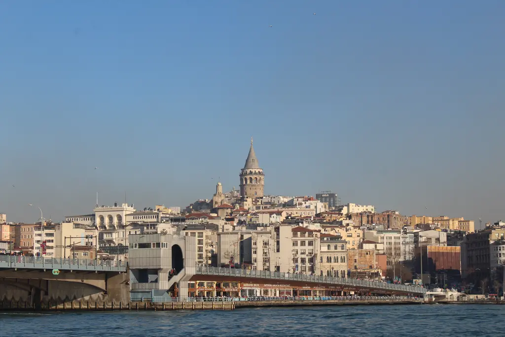 Haliç'ten Galata; önde Galata Köprüsü ile kıyıdaki yapılar, yamaca dizilen binalar ve tepede Galata Kulesi.