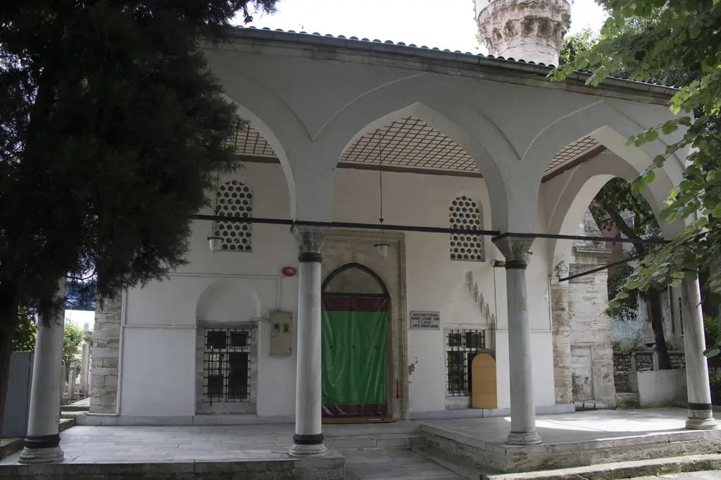 Eyüp'te Defterdar Camii; kesme taş duvarlı dikdörtgen yapı, sütunlu son cemaat yeri, yeşil kapı ve sağda minare.