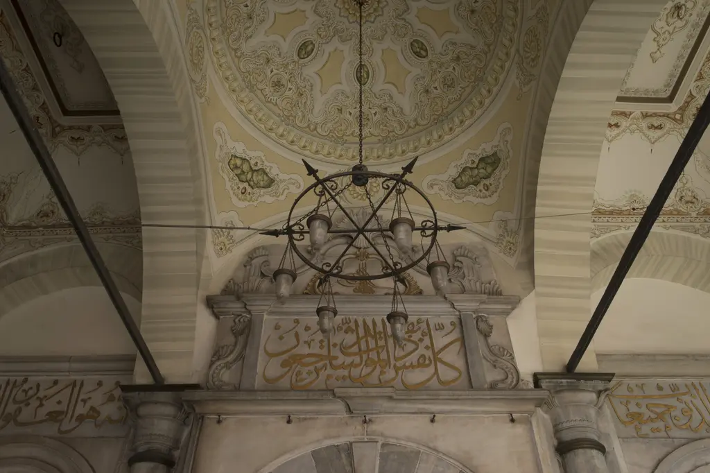 Şah Sultan Türbesi'nin revak kubbesi; kalem işi süslemeler, demir kandil askısı ve kapı üstünde altın yaldızlı yazı.