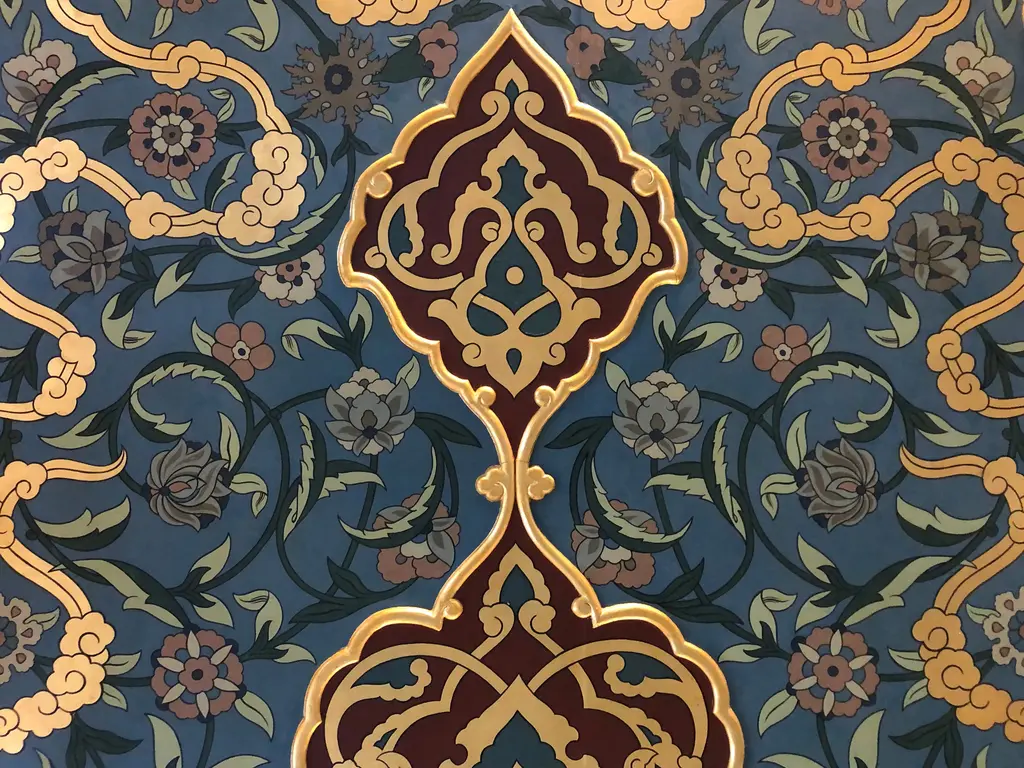 Şişli Camii'nde kalem işi motif; lacivert zemin üzerinde bordo ve altın sivri kemerli göbek, çevresinde çiçek ve yapraklar.