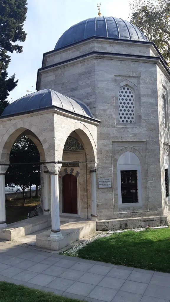 Barbaros Hayreddin Paşa Türbesi; yandan bakışta kubbeli sekizgen gövde, önünde küçük kubbeli revak ve çimenler.