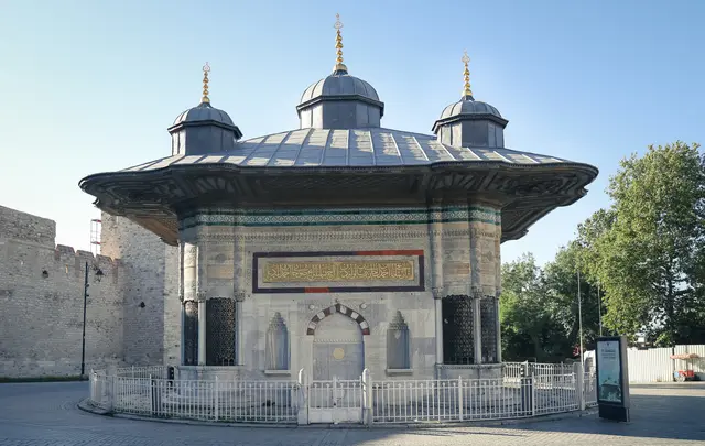 III. Ahmet Çeşmesi; kare planlı mermer gövde, geniş saçaklı kurşun çatı, tepesinde beş kubbecik ve çevresinde alçak demir parmaklık.