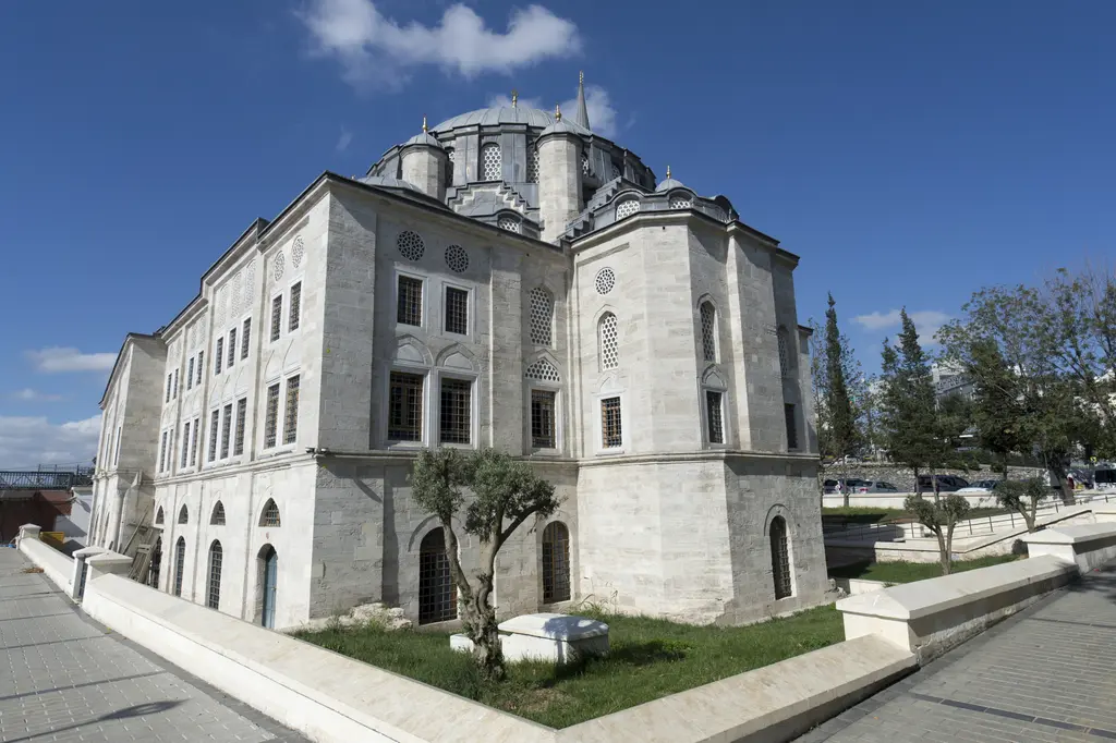 Azapkapı Sokullu Mehmed Paşa Camii'nin köşesi; taş gövdede pencere sıraları, kubbe kasnağı, ağırlık kuleleri ve önde zeytin ağacı.