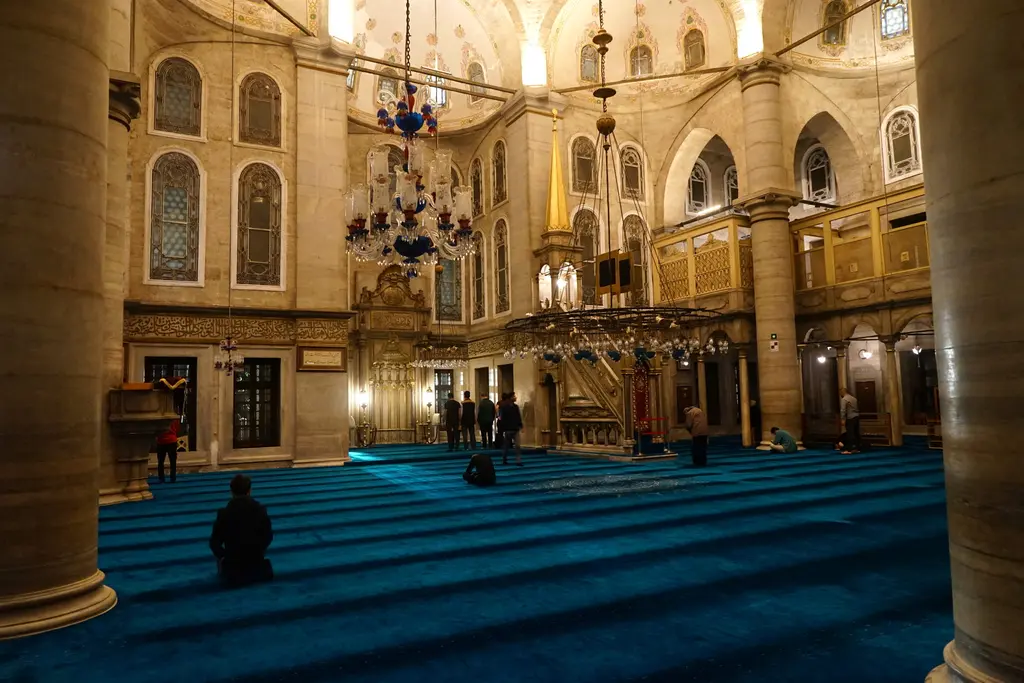 Eyüp Sultan Camii'nde harim; turkuaz halı, yaldızlı mihrap duvarı, minber, avize ve iki yanda mahfiller.