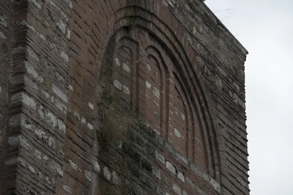 Gül Camii'nin batı köşesinde duvar dokusu; almaşık tuğla ve taş bantlar, tuğla kemer sıraları ve içe çekilmiş çok kademeli bir kör kemer.