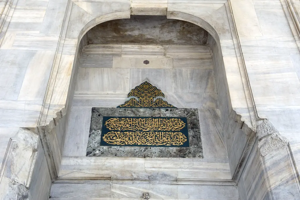 Murat Paşa Camii kapısının üstünde yazı; palmet biçimli altın aynalı hat ve altında lacivert zemin üzerine altın yaldızlı kitabe.