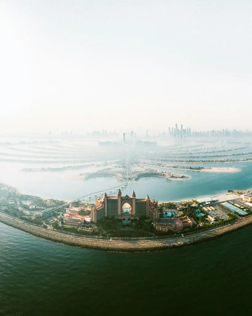 Palm Jumeirah'nın havadan görünümü; palmiye ağacı biçiminde yapay ada, dalları üzerindeki villalar ve çevresindeki deniz.