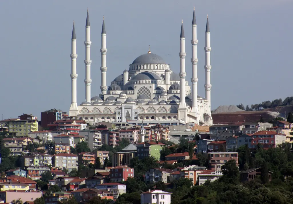 Büyük Çamlıca Camii; yeşil yamaca yayılan konutların üstünde altı minareli beyaz cami ve kubbeleri.
