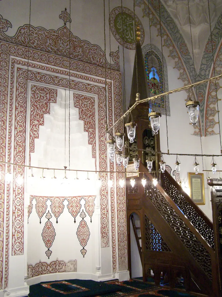 Firuz Ağa Camii'nde mihrap ve minber; mukarnaslı alçı mihrap, ahşap minber, kalem işi duvar süslemeleri ve kandiller.