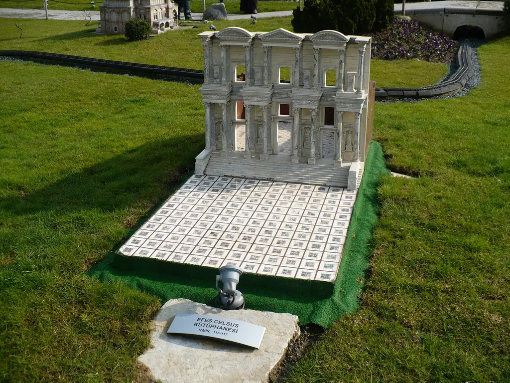 Miniatürk'te Celsus Kütüphanesi maketi; beyaz iki katlı sütunlu cephe, önünde kare desenli taş avlu, arkada minyatür tren rayı.