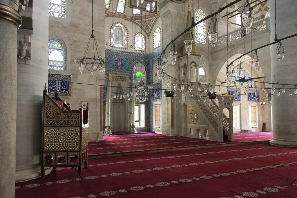 Kılıç Ali Paşa Camii'nde kıble duvarı; solda ahşap vaaz kürsüsü, ortada mihrap, sağda mermer minber ve kırmızı halı.
