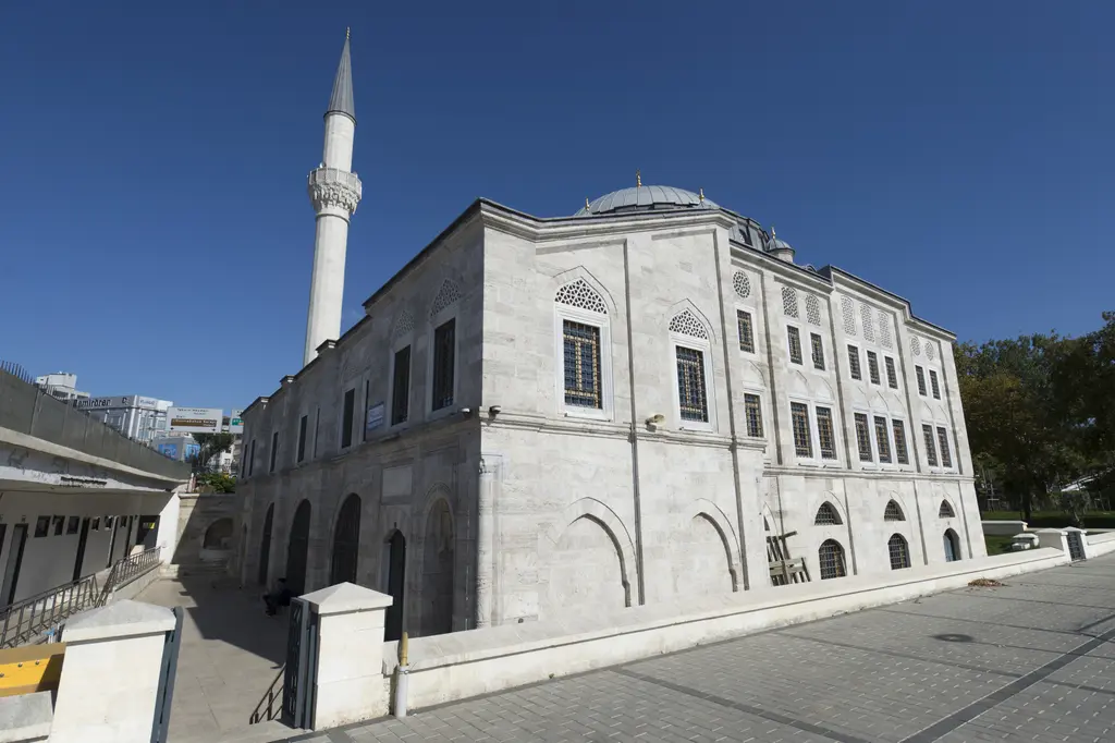 Azapkapı Sokullu Mehmed Paşa Camii; köşeden bakışta taş gövde, kurşun kaplı kubbe, şerefeli ince minare ve koyu mavi gökyüzü.