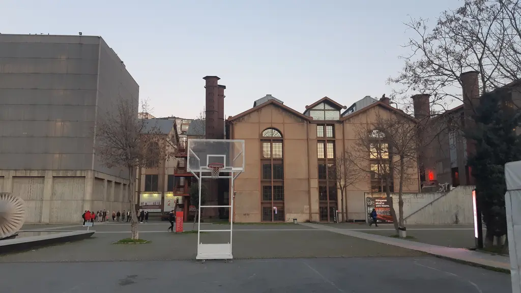 Santralistanbul kampüsü; tuğla santral binaları, modern beton yapılar, basketbol potası ve geniş meydan.