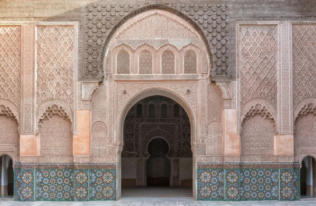 Marakeş'te Ben Youssef Medresesi; çini ve alçı işlemeli iç avlu, ortadaki havuz ve simetrik kemerler.