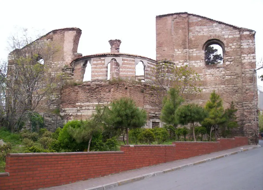 İmrahor İlyas Bey Camii'nin caddeden görünüşü; solda yıkık yan duvarlar, ortada çokgen apsis ile kemerli pencereli kasnak, sağda büyük kemerli pencereli doğu cephesi.