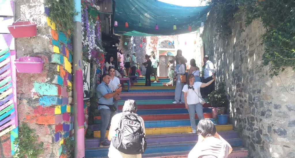 Balat'ta rengârenk boyalı merdivenler; basamaklarda oturan ve çıkan insanlar, duvarlarda renkli süslemeler.