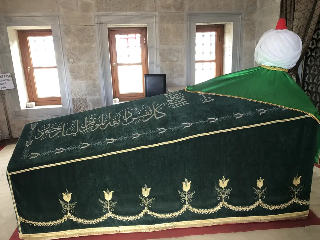 Şemsi Ahmed Paşa Türbesi'nin içi; yeşil örtülü sanduka, başında beyaz sarık ve kemerli pencereler.