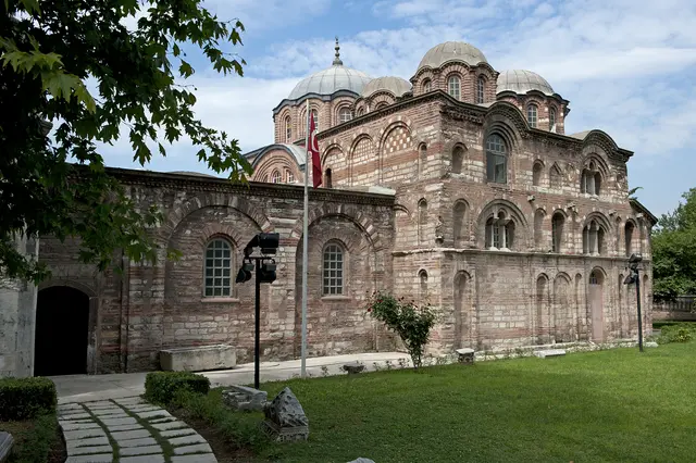 Çarşamba'da Fethiye Camii'nin güney cephesi; tuğla ile taşın sıra sıra değiştiği duvar, kör kemerli nişler, üstte kubbeler ve solda beyaz minare.