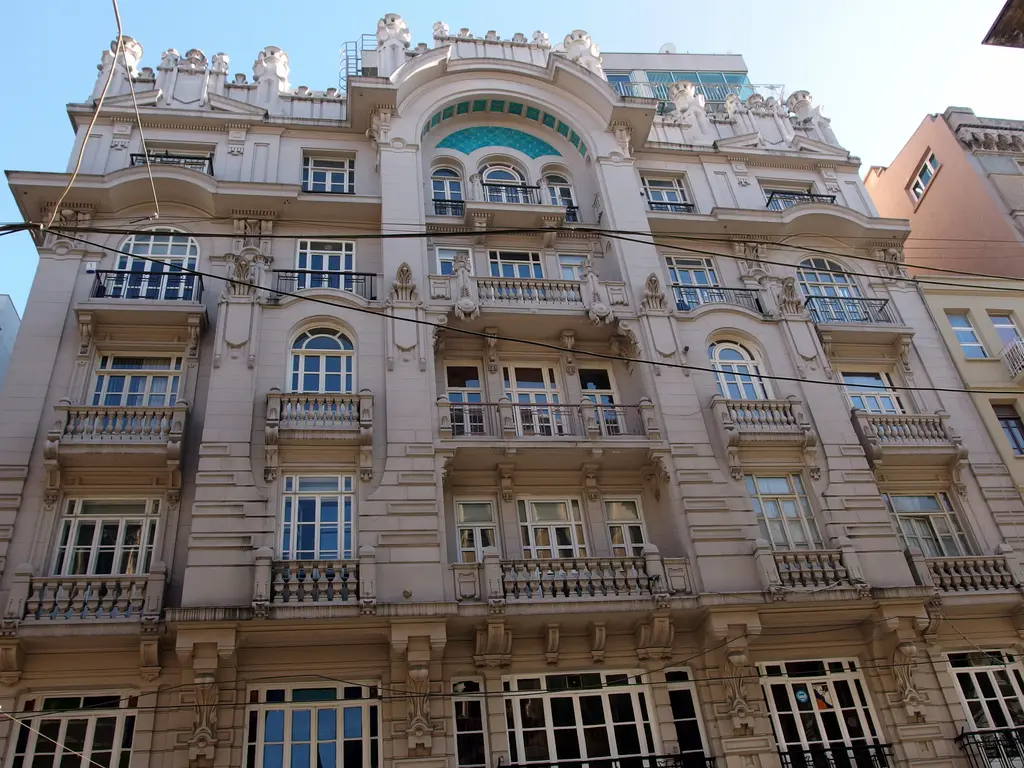 İstiklal Caddesi'nde Mısır Apartmanı; beyaz süslü taş cephe, kemerli pencereler, balkonlar ve üst katta yuvarlak pencere.