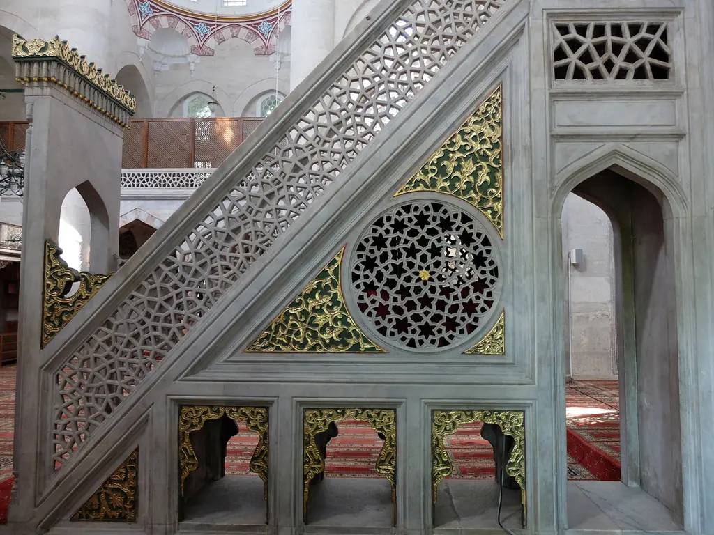 Nişancı Mehmed Paşa Camii'nin mermer minberi; geometrik şebekeli korkuluk, yaldızlı yüzeyler, yuvarlak kafes pano ve kemerli alt açıklıklar.