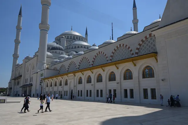 Üsküdar'da Büyük Çamlıca Camii; beyaz taş cephe, kemerli pencereler, kubbe kümesi ve gökyüzüne yükselen minareler.