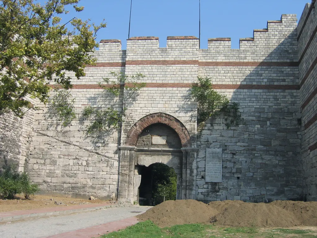 Edirnekapı'nın kemerli geçidi; iki yanda yüksek taş duvar, üstte mazgallı siper, kemerin üstünde kırmızı tuğla kuşaklar.