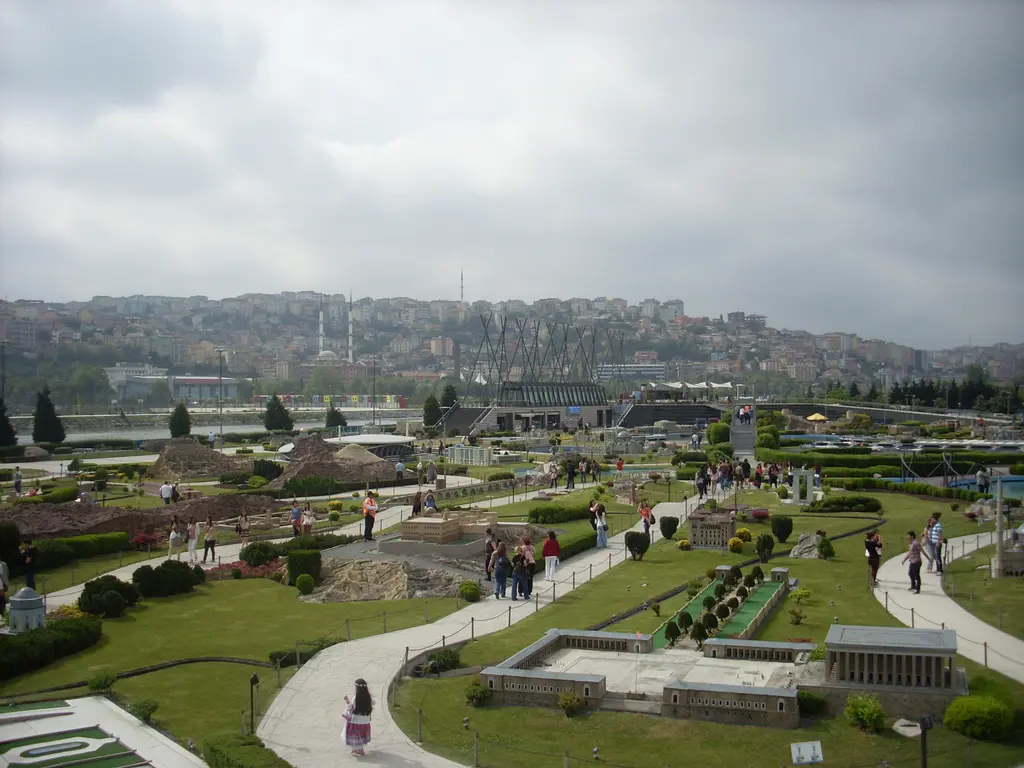 Miniatürk'te maket alanına yukarıdan bakış; çimenler arasında kıvrılan gri yollar, sağ önde Anıtkabir maketi, arkada ağaçlar ve tepedeki evler.