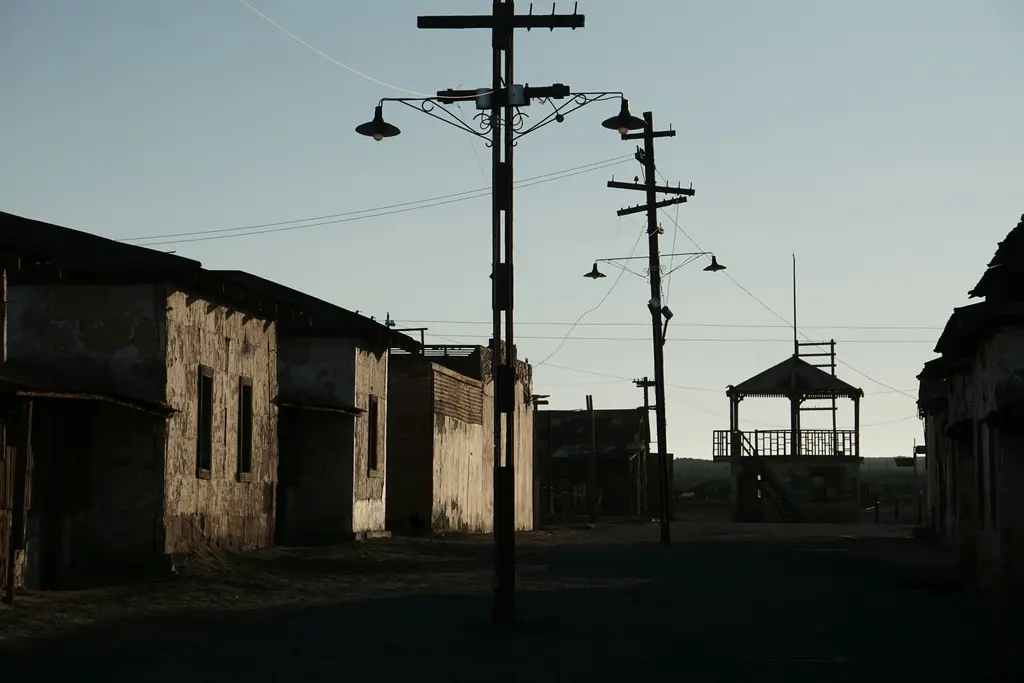 Humberstone; çölde terk edilmiş, çatısız kalmış yapıların sıralandığı sokak ve yana yatmış elektrik direkleri.