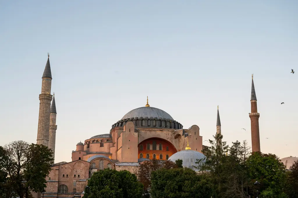 Sultanahmet'te Ayasofya'nın taş cephesi; ortadaki büyük kubbe, iki yanda yükselen ince minareler ve sıra sıra kemerli pencereler.