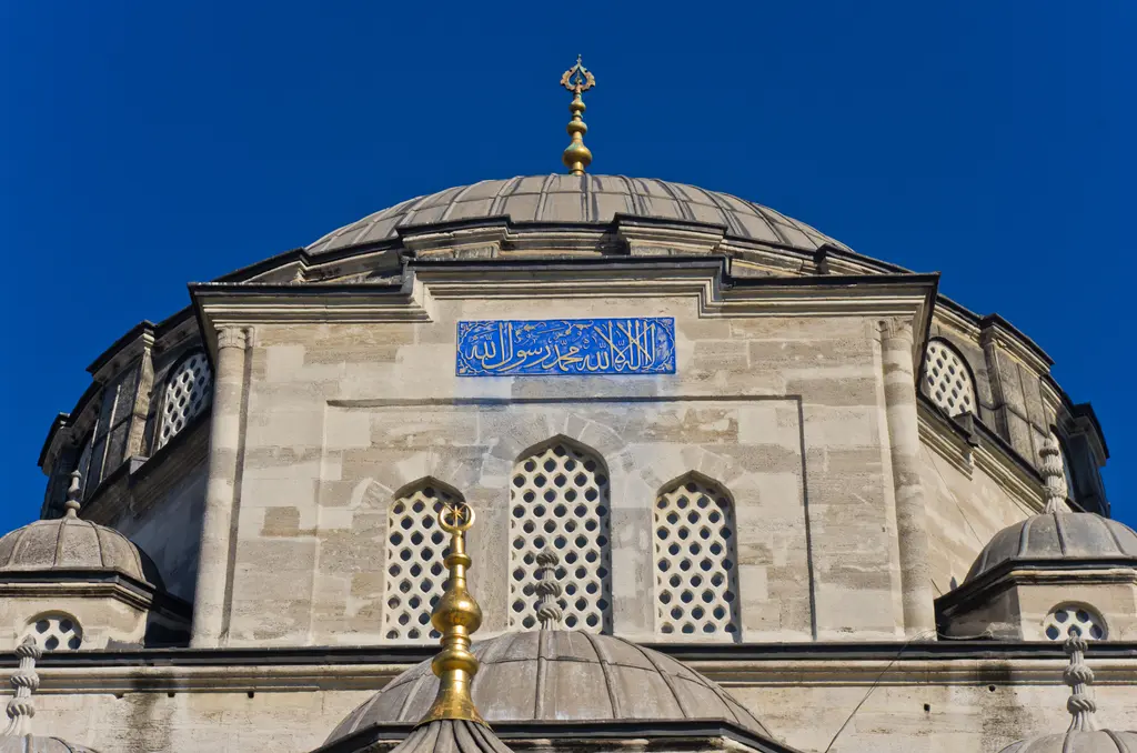 Sokullu Mehmed Paşa Camii'nde kubbe ve kasnağı; dışarıdan kurşun kaplı kubbe, yuvarlak kemerli kasnak pencereleri, alem ve çini pano.
