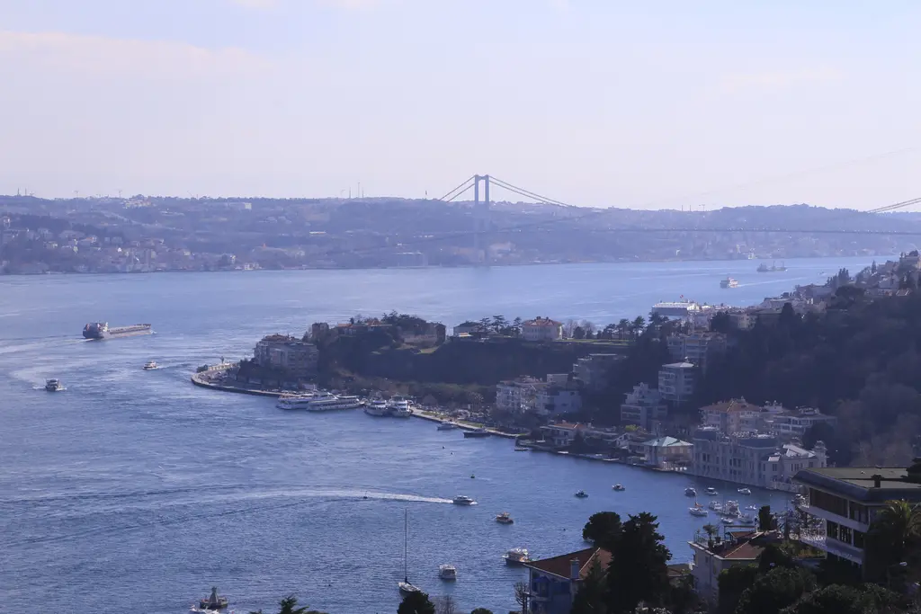 Boğaziçi Üniversitesi'nden Boğaz; aşağıda kıyıya uzanan burun, tekneler, karşı kıyı ve uzakta asma köprü.