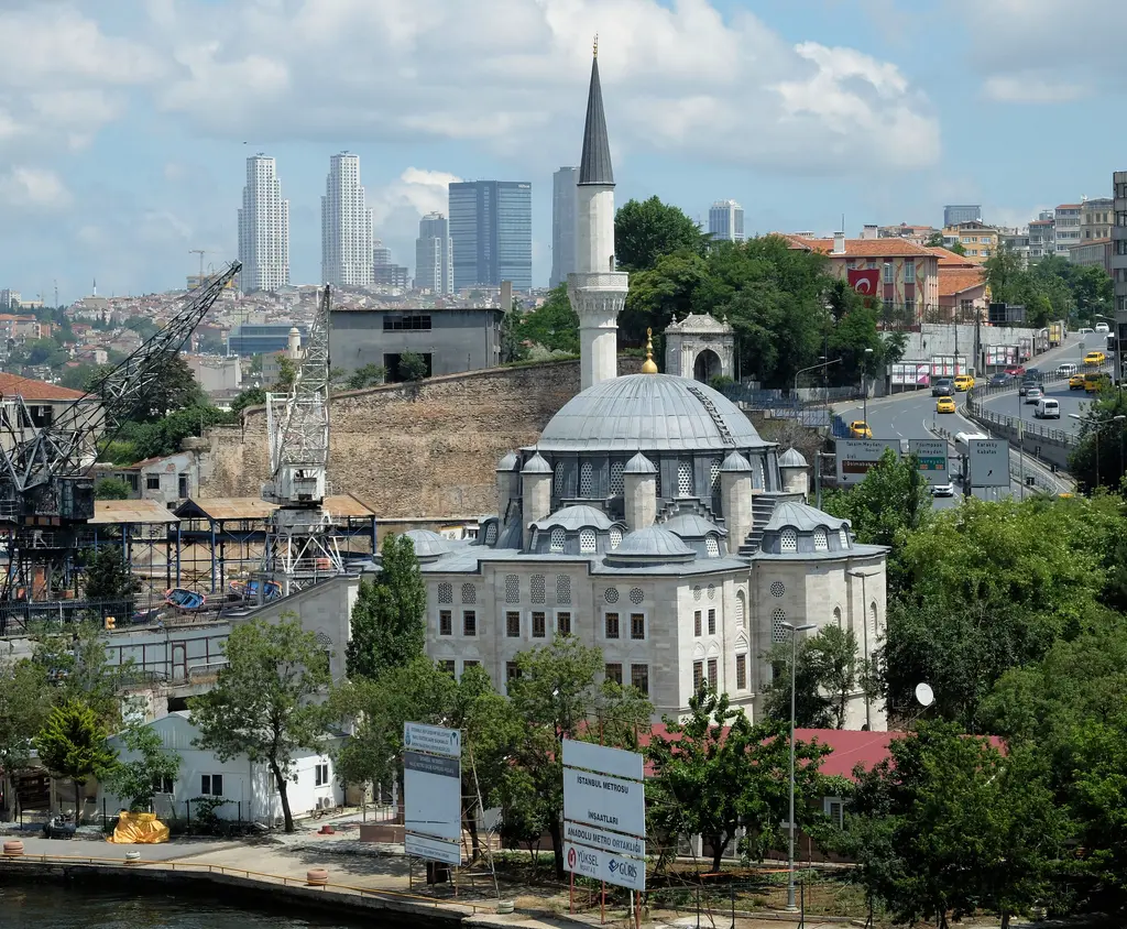 Yukarıdan Azapkapı Sokullu Mehmed Paşa Camii; kurşun kubbeler ve minare, çevresinde ağaçlar, arkada Haliç kıyısı ve uzakta yüksek binalar.